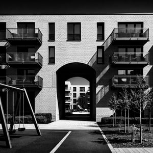A highcontrast black and white architectural photograph of a modern residential apartment building based on the composition of image0png The scene is